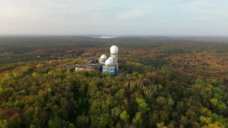 smooth aerial view flight architectural ruin in autumn forest at morning sunrise, devil's mountain in woods berlin october 2022