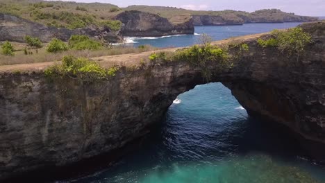 spectacular aerial view flight fly forwards drone shot natural bridge
broken beach at nusa penida bali