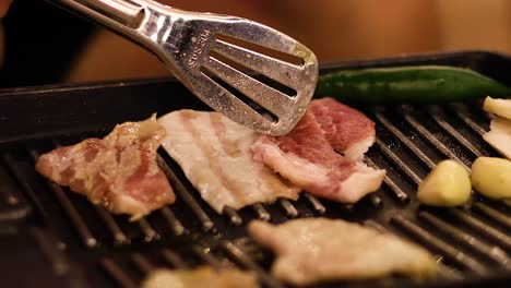 sizzling bacon and veggies on a stovetop grill