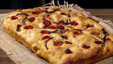 Focaccia-Italiana-Tradicional-Con-Pepperoni,-Tomates-Cherry,-Aceitunas-Negras,-Romero-Y-Cebolla---Focaccia-Casera-De-Pan-Plano