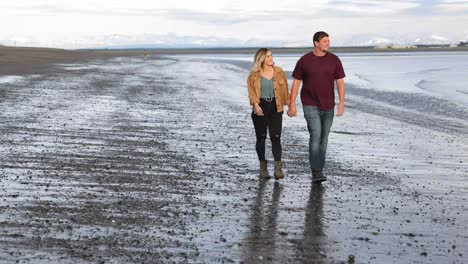 couple walking on beach in kenai, alaska