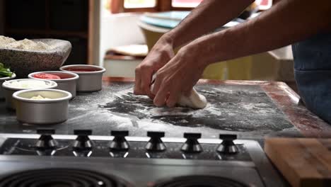 chef preparando pizza de masa fermentada estirándola con las manos