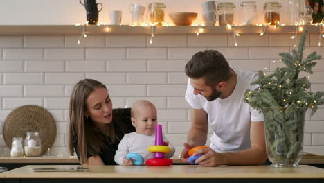 familia joven feliz con un bebé recién nacido. madre, padre y bebé recién nacido. madre y padre felices besándose y abrazando al bebé. concepto de paternidad. cámara lenta