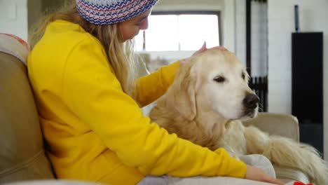 mujer acariciando a su perro en el sofá en casa 4k