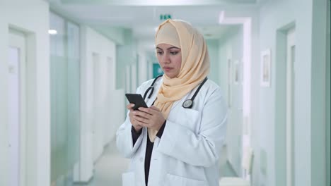 muslim doctor messaging someone on phone