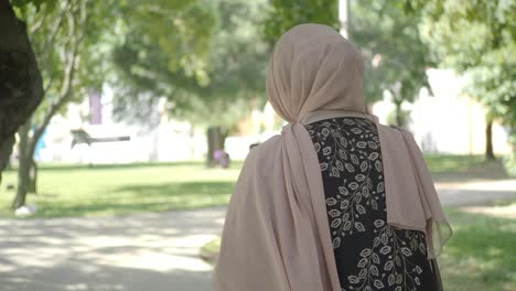 mujer en hijab caminando en un parque