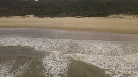 Man-running-with-soccer-football-ball-in-Playa-grande-Beach,-Punta-del-Diablo-in-Uruguay