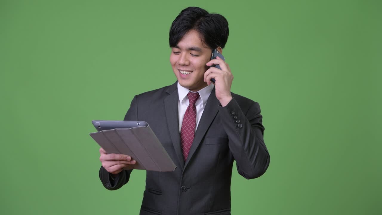 joven empresario asiático guapo usando una tableta digital