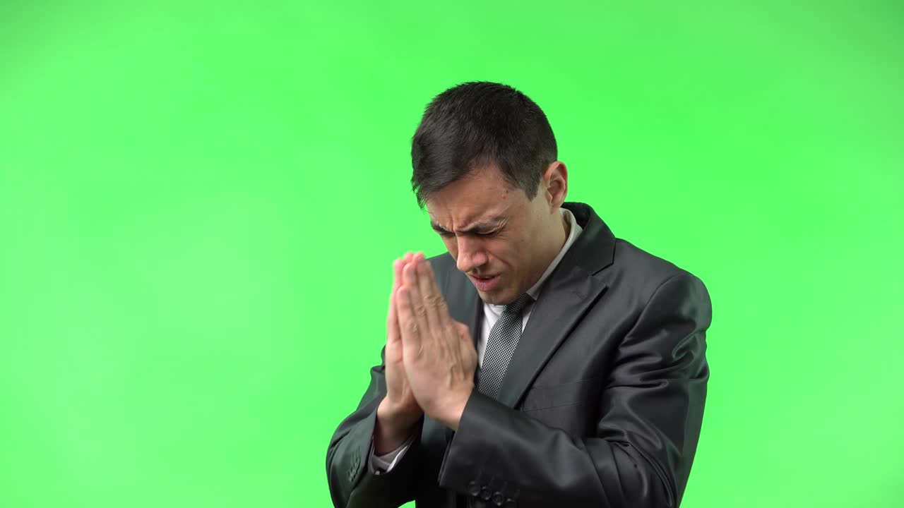 Man in Suit Praying on Green Screen