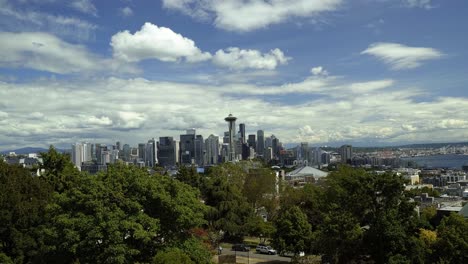 beautiful tilting up shot revealing the stunning city of seattle from kerry park with the famous space needle, skyscrapers, and residential homes surrounded by trees on a summer day in washington