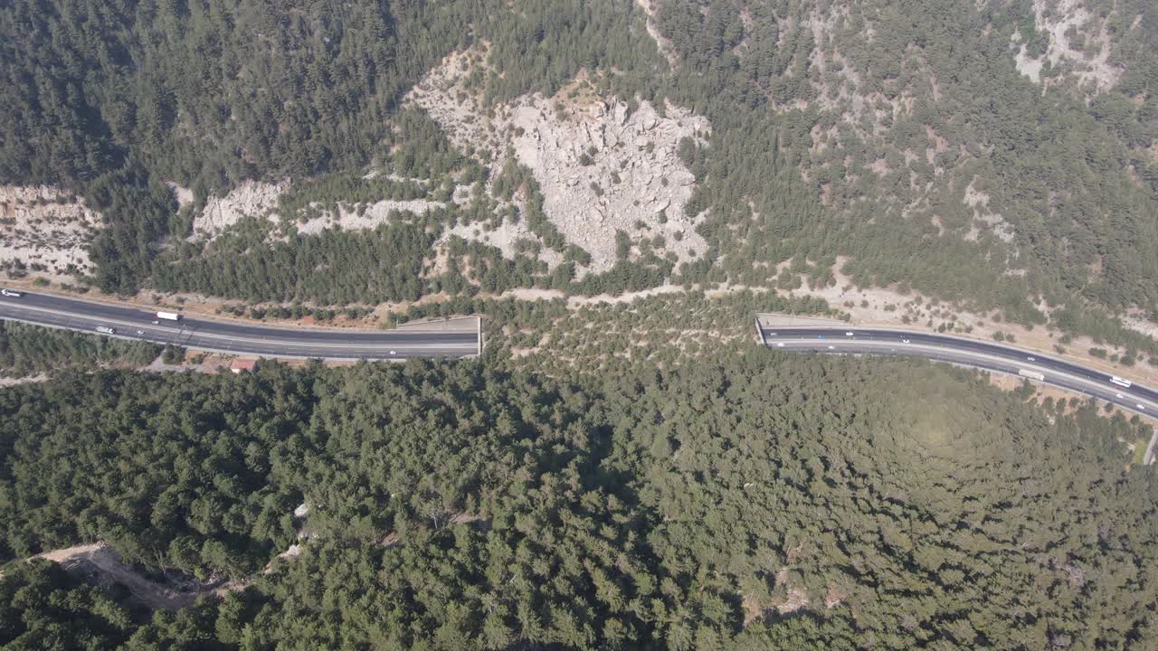 дронный вид движения транспортных средств на дороге и туннеле, построенном между горами, междугородный транспорт