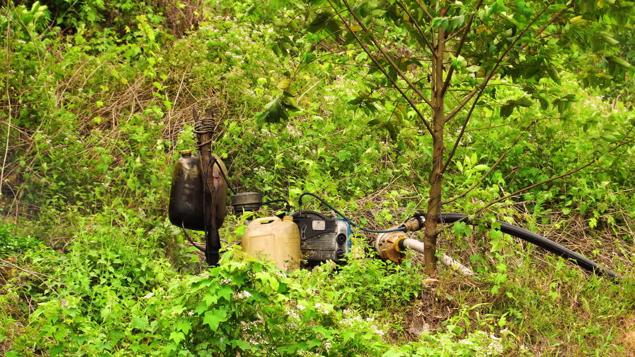 베트남 정글에 있는 물 식물에 물을 위쪽으로 펌핑하는 오래된 휘발유 물 펌프