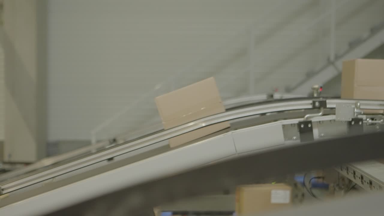 A cardboard box travels on a conveyor belt in a warehouse distribution center