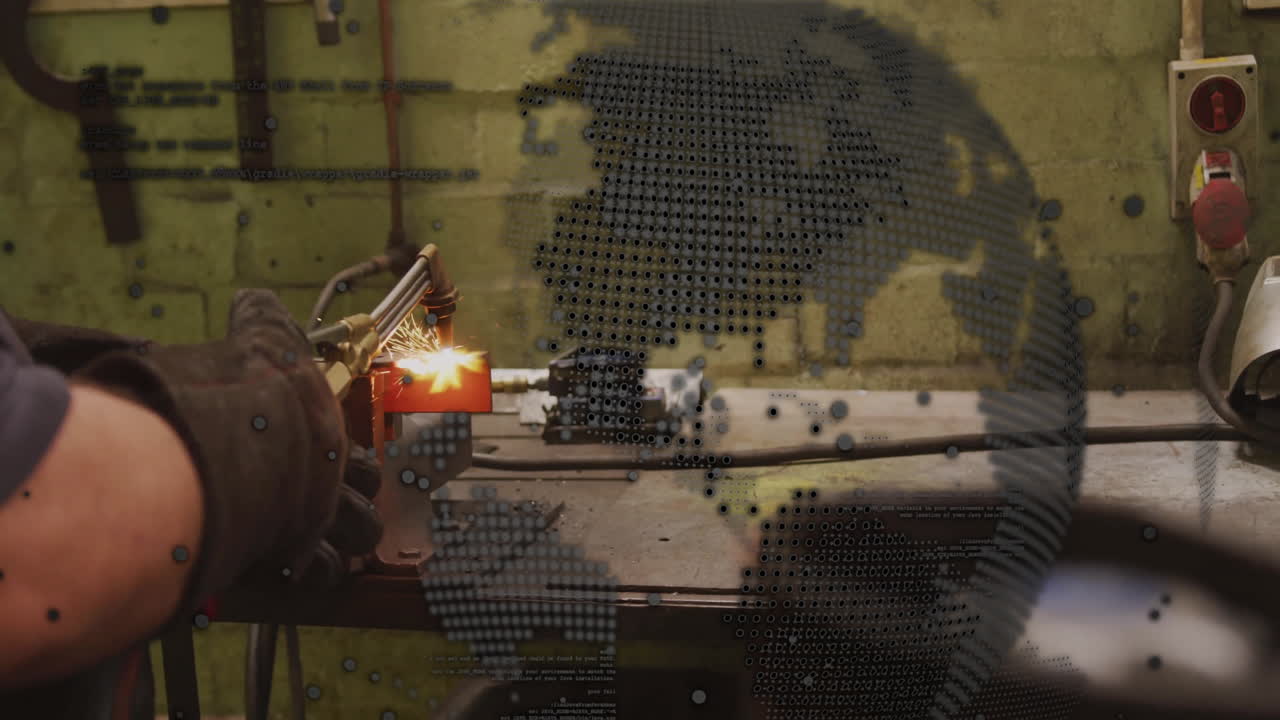Metalworker using gas cutting torch in metalworking workshop, showing glowing sparks and world map