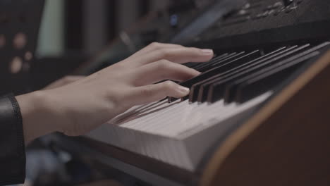 close-up hands playing electronic piano
