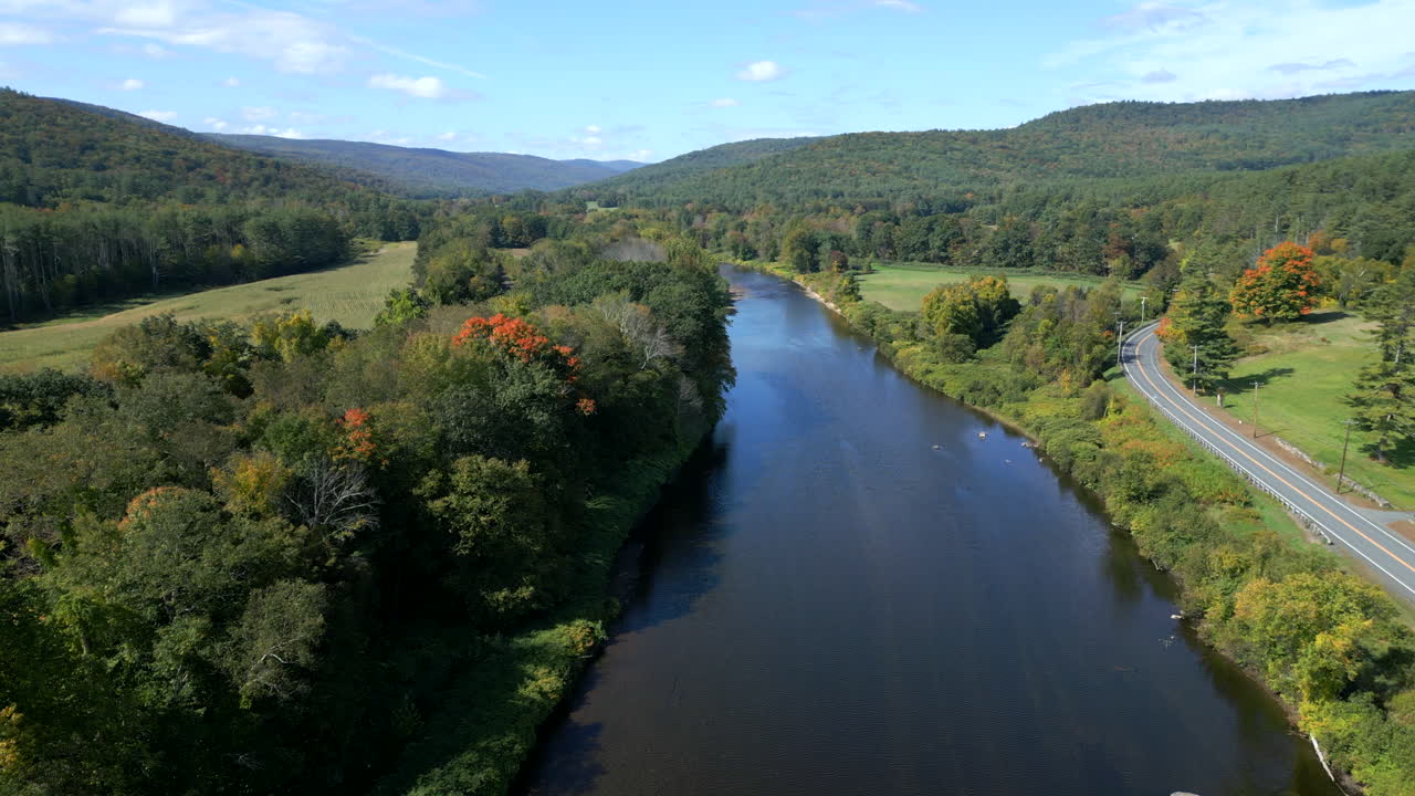 Drone rises following bend in river of Mohawk Trail by Deerfield River in Western Massachusetts New England USA
