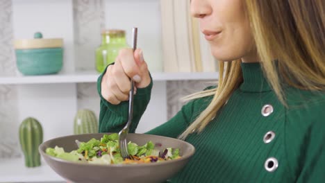 la mujer come ensalada para mantenerse en forma.