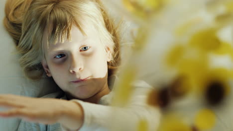 blonde girl playing with balloons lying on the bed hitting his balls laughing