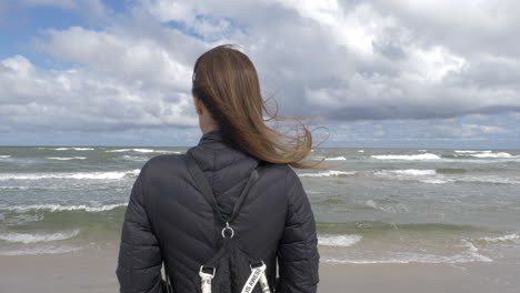 cinematic shot of woman admiring the ocean and the waves-1