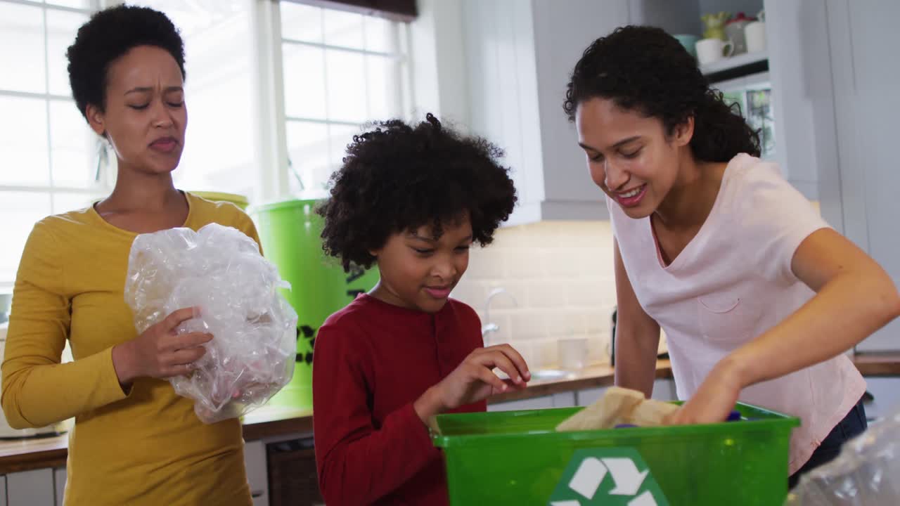 Mixed race lesbian couple and daughter cleaning kitchen