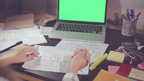 woman working on house plans at a desk.