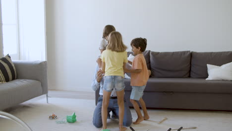 joyful father having fun with children in living room