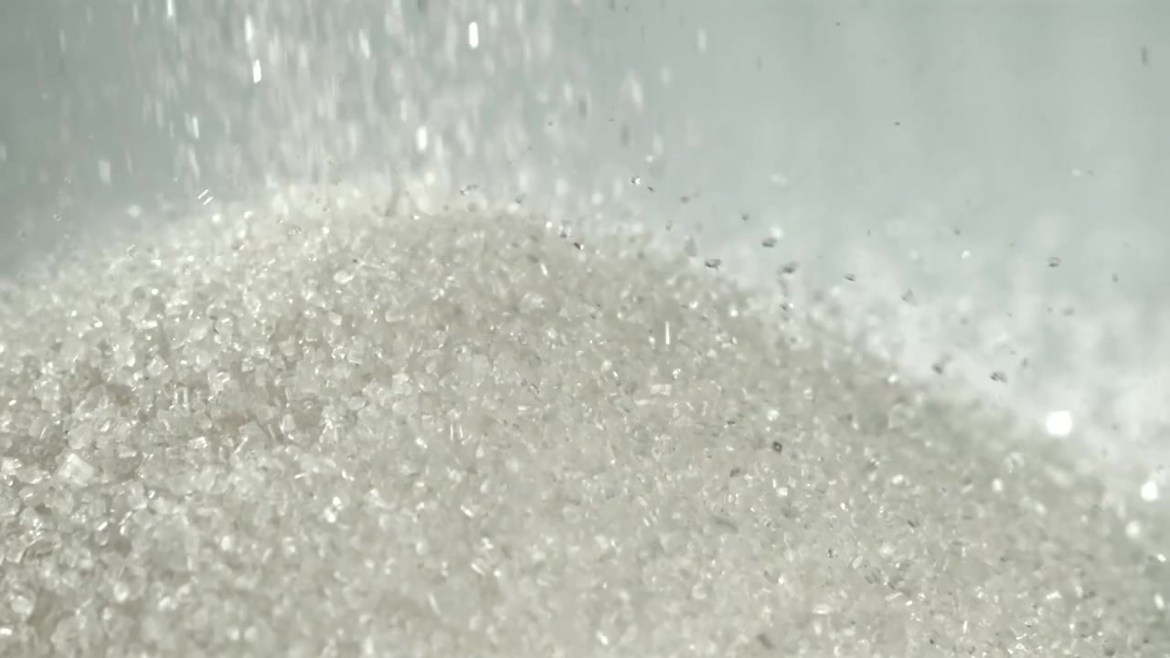 Primo piano di zucchero semolato bianco in caduta