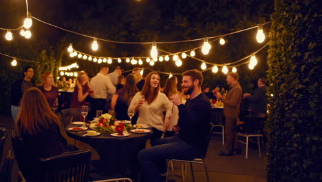 blurred outdoor evening party with string lights and guests