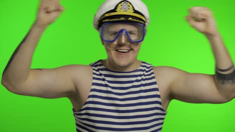 emotional man tourist in underwater mask, striped sailor shirt dances celebrates