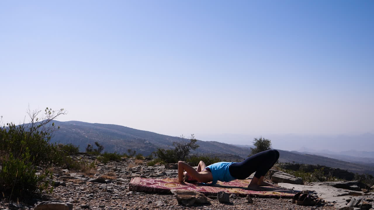 Umman'da açık havada yoga yapan Batılı gezgin kız, diğer kliplerde farklı pozlar mevcut.
