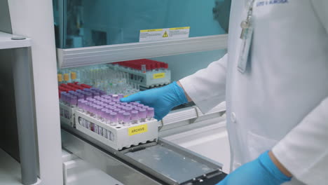 putting test tube racks inside a medical laboratory equipment