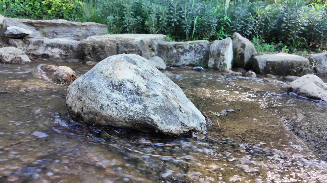 Clear Water Flowing Over Rocks in a Peaceful Stream
