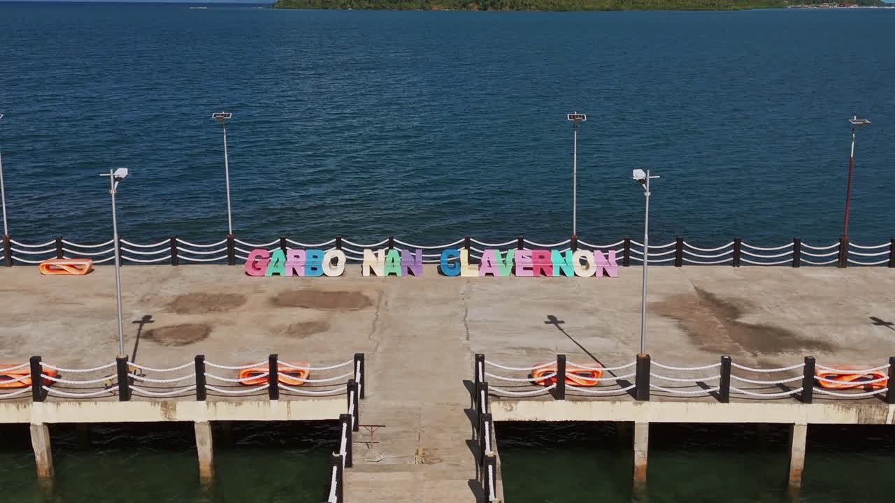 A large colourful sign saying 'Garbo Nan Clavernon' translating to 'Claver is Proud' on Claver Boulevard, Surigao Del Norte, Philippines on a bright sunny day