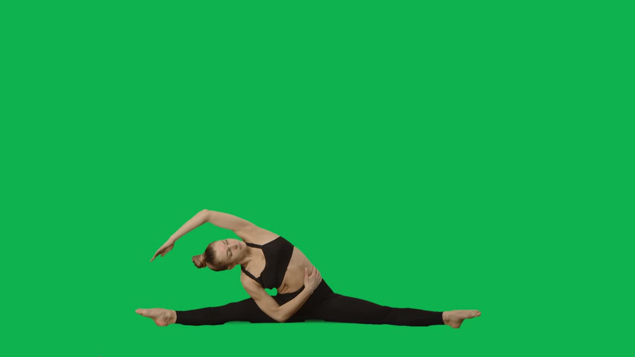 Junge Frau in Sportkleidung macht Yoga, dehnt den Körper. Training, Fitness für Frauen, Aerobic. Seitenansicht in voller Länge vor Greenscreen-Hintergrund. Zeitlupenbereit 59.94fps.