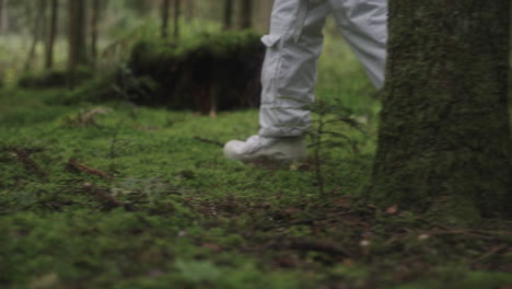 Astronaut-in-space-suit-walking-trough-forest