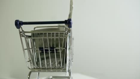 carrito de compras con billetes de 100 dólares en fondo blanco venta de comercio electrónico en línea estrategia de marketing exitosa