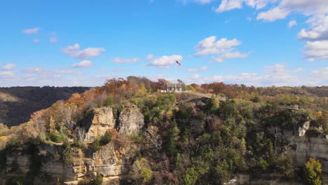 Colorful-Fall-Bluff-with-an-American-flag-on-the-pole-at-the-top-of-the-mountain