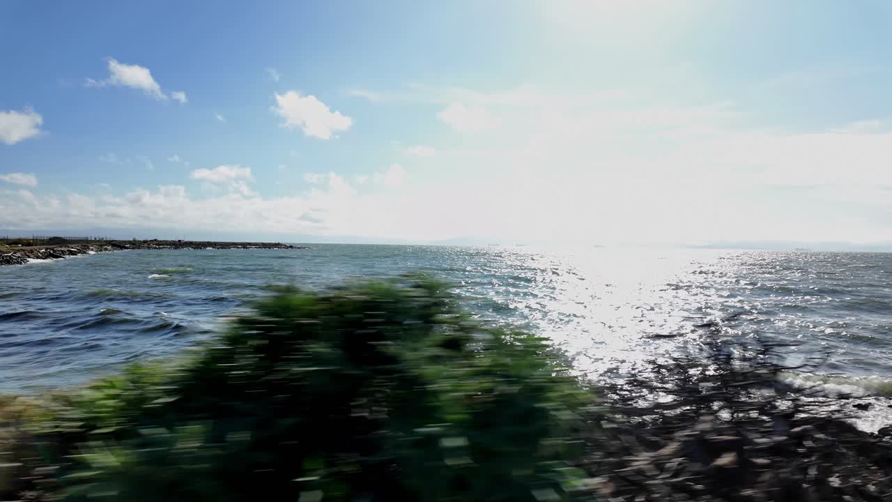 A right-to-left pan reveals the coast of Bay Farm Island, California, capturing the shoreline’s calm waters and expansive horizon with a serene atmosphere along the East Bay
