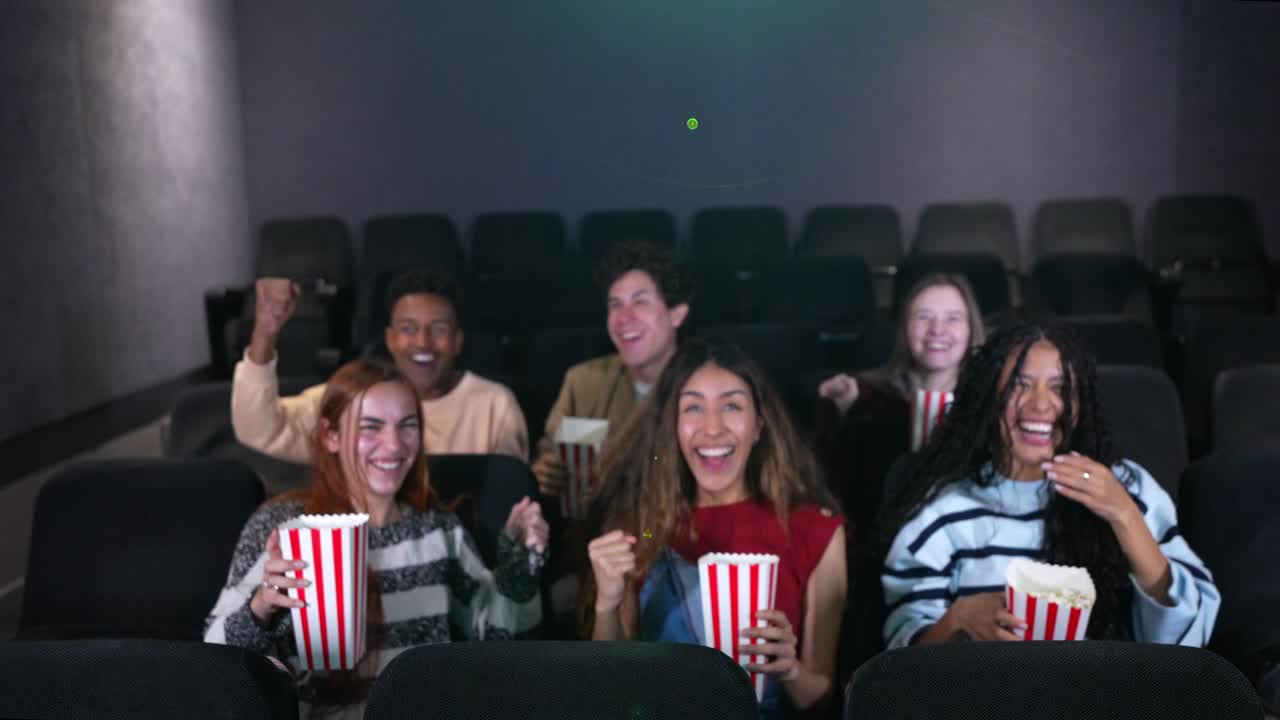 Amici entusiasti che si godono un film al cinema con i popcorn