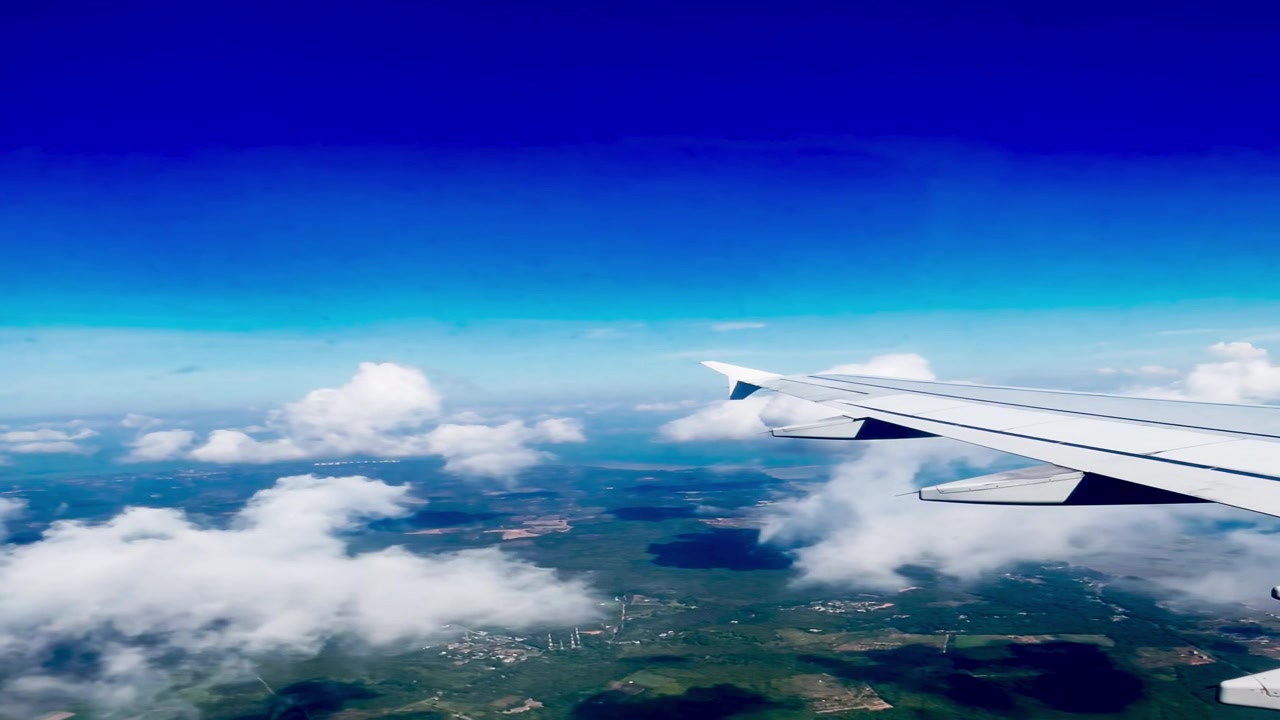 Vista aerea dell'ala dell'aereo sopra nuvole e paesaggio