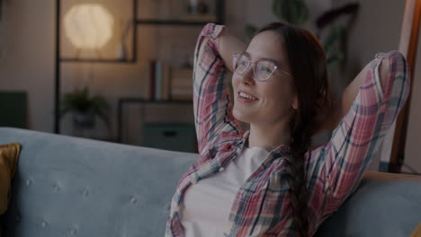una mujer joven relajándose en un sofá.