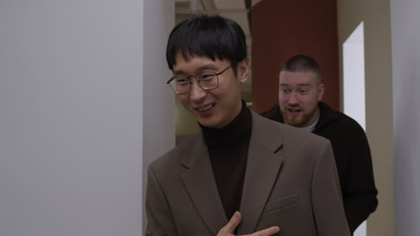 two colleagues in conversation in an office corridor