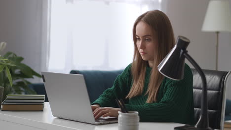 Konzentrierte-Frau-Arbeitet-Zu-Hause-Und-Tippt-Text-Auf-Der-Tastatur-Eines-Laptops.-Fernarbeit-Für-Junge-Frauen-Im-Mutterschaftsurlaub.-Frauenporträt-Im-Zimmer