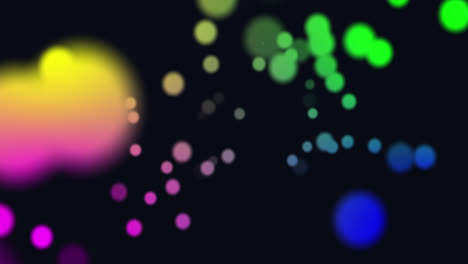 animation of multi coloured glowing spots of light moving in hypnotic motion on black background