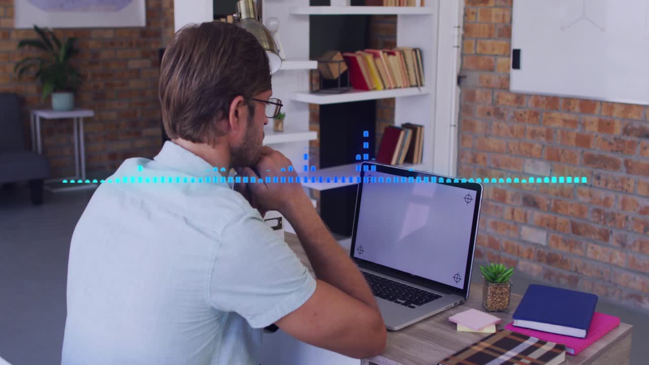 Man leaning at desk studying laptop while waveform moving across screen for tech calibration