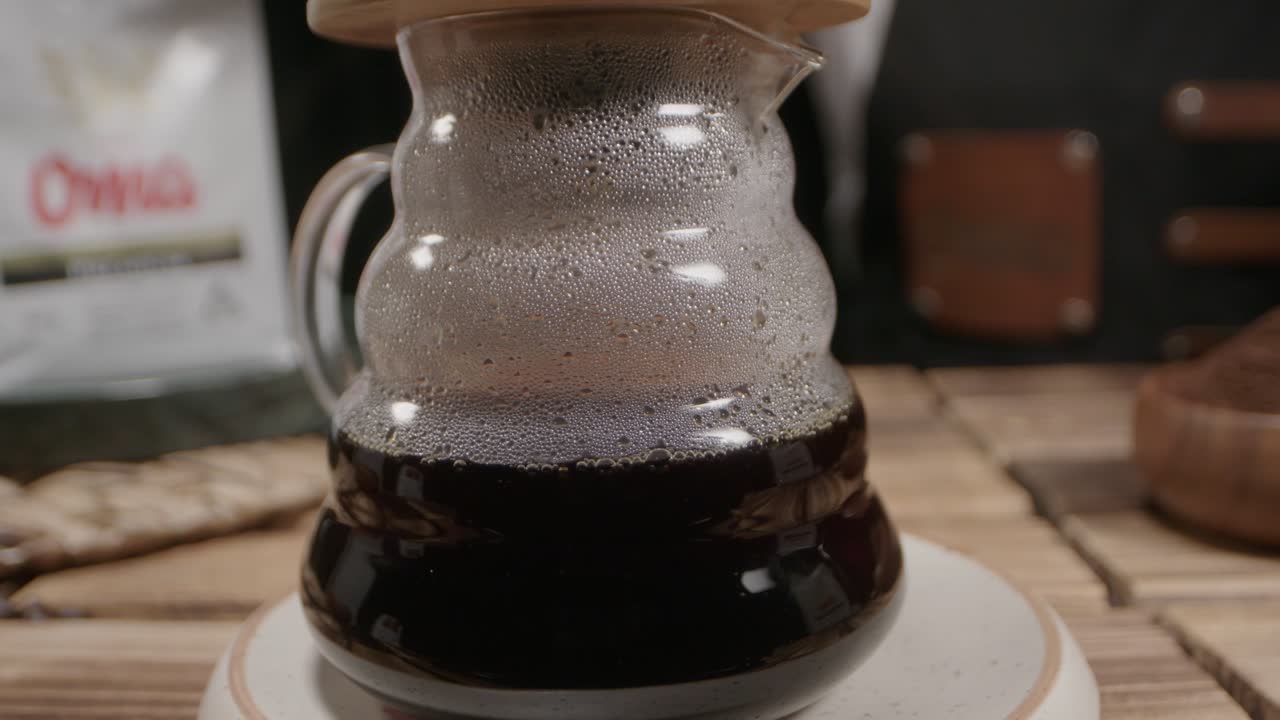 Freshly brewed coffee in a glass jar, steam clinging to the surface, evokes warmth and comfort, capturing the essence of a cozy and authentic coffee ritual