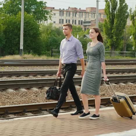 Two-Businessmen-With-Luggage-Go-Along-The-Railroad-1