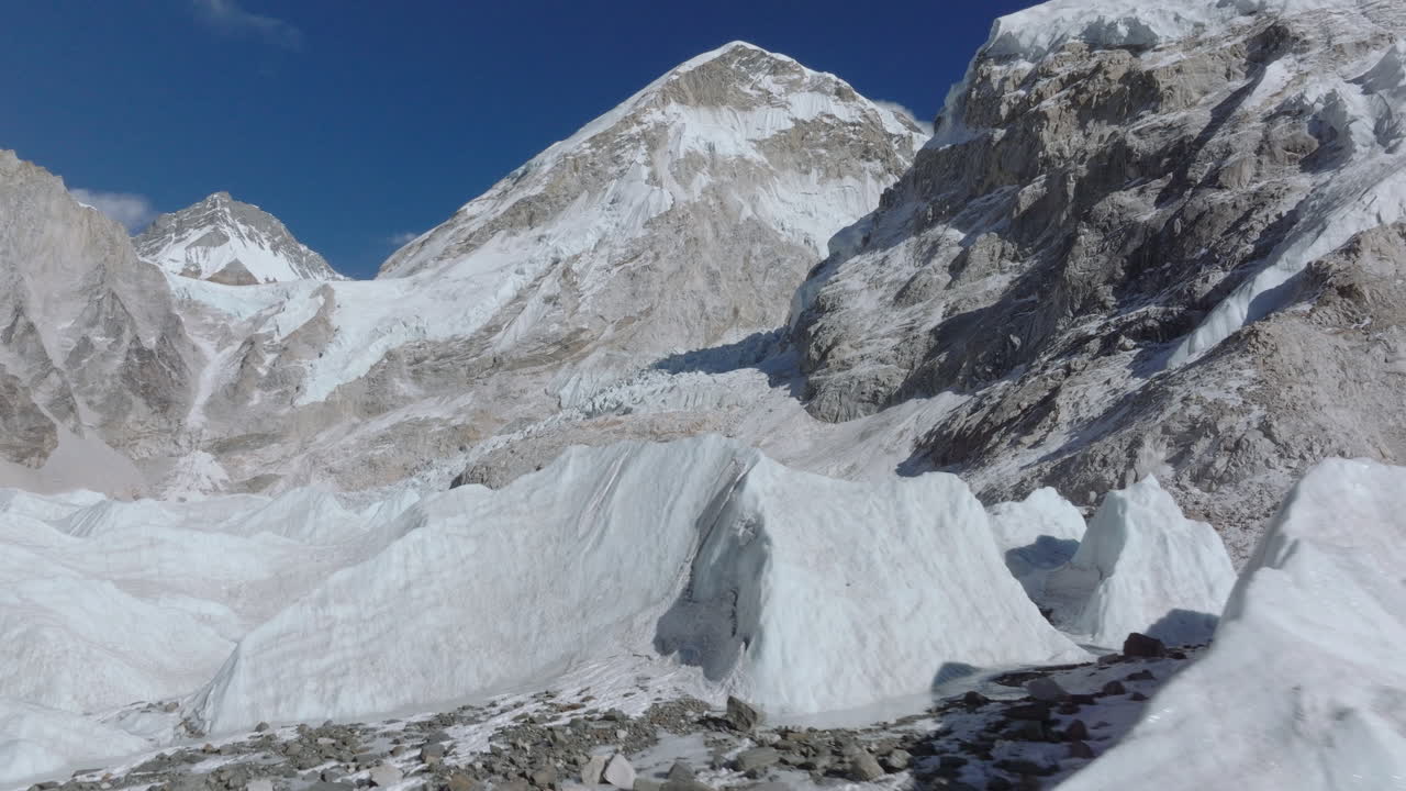 Torre di ghiaccio che si forma dal ghiacciaio Khumbu vicino al Campo Base dell'Everest che in seguito si scioglie in acqua, evidenziando la trasformazione del ghiacciaio e il riscaldamento climatico nella regione dell'Himalaya del Khumbu, Nepal