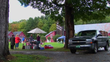 Families-picnic-near-trees-and-red-barns-at-a-Country-Fair-in-Vermont