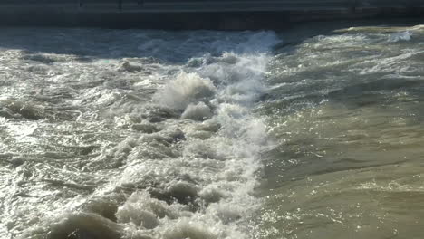 extreme slow motion view of powerful river water flowing down a weir waterfall